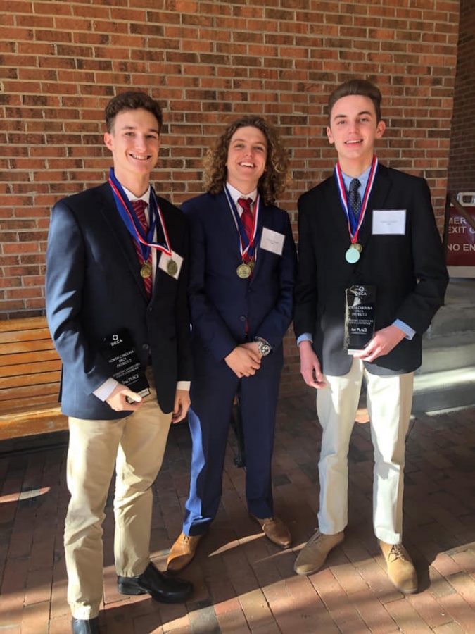 Dotson, Powell, and Walker flashing their awards for placing in their events at districts.