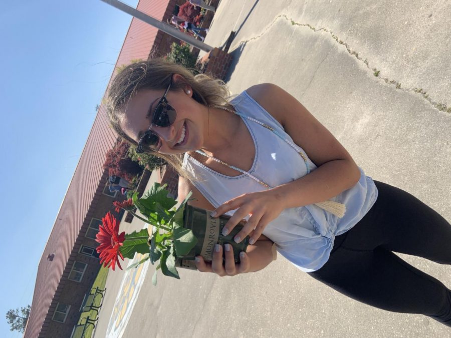 Senior Chloe Lach represents Key Club by helping plant flowers.