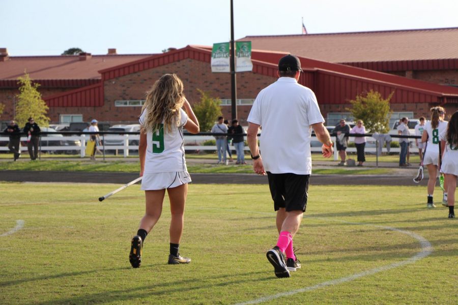 Chloe Lach crosses the field with her coach. 