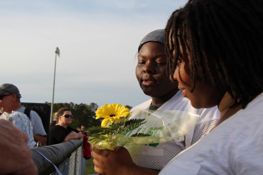 Molysha "Moe" Brown looks at a flower as she stands with her younger sister, Meldrina Brown