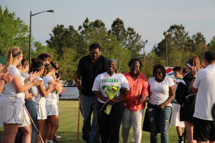 Goalie and captain Molysha Moe Brown walks through the tunnel accompanied by her father, mother, and younger sister. 