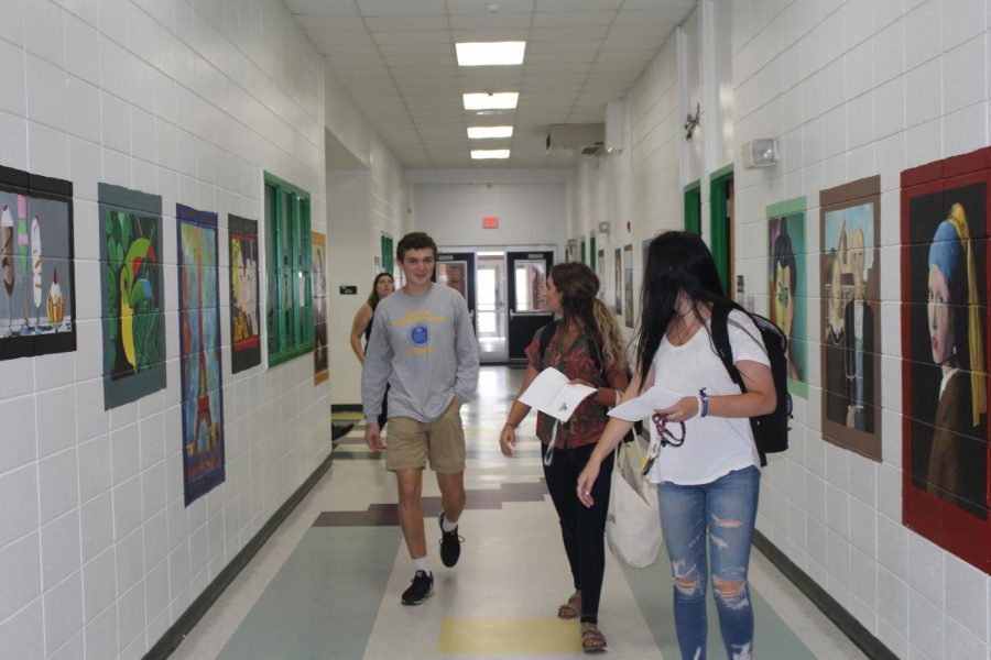 Connor Gushman, Rayna Gunther, and Chloe Lach walking through the hallways without a care in the world.