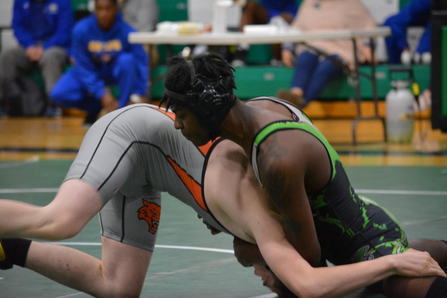 Senior Alex Williams goes up against Wildcats opponent to try and get a pin for the Trojans!