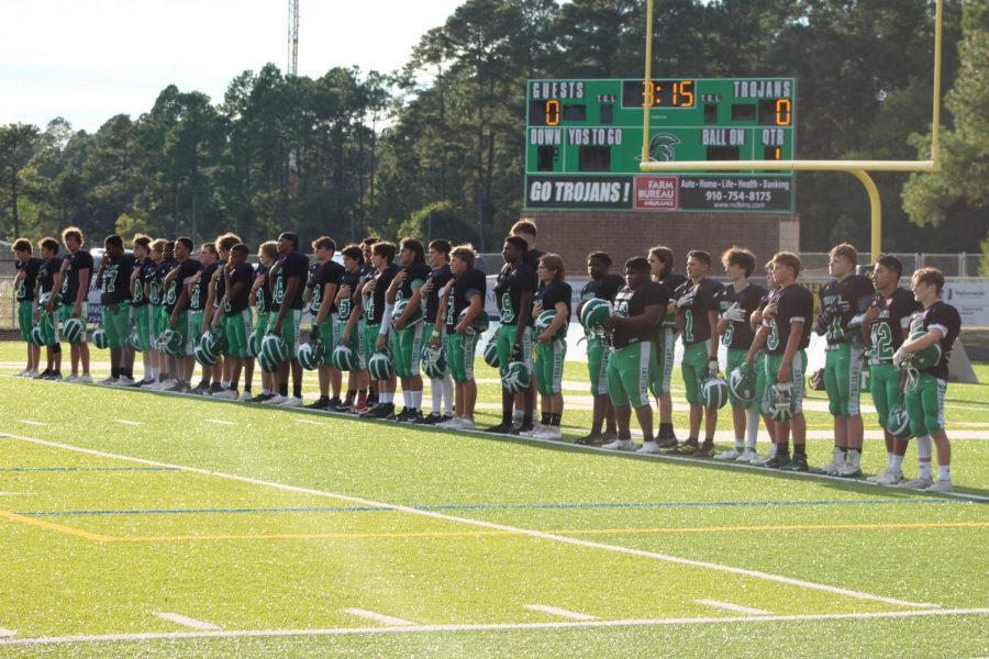 The Trojans JV Football Team stands for the National Anthem. 