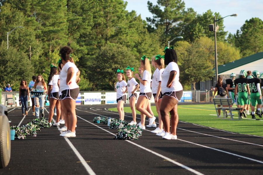 The Trojan Cheerleaders cheer on the football team from the side lines.