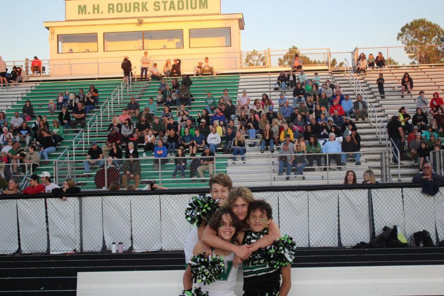 A group of cheerleaders huddle together.