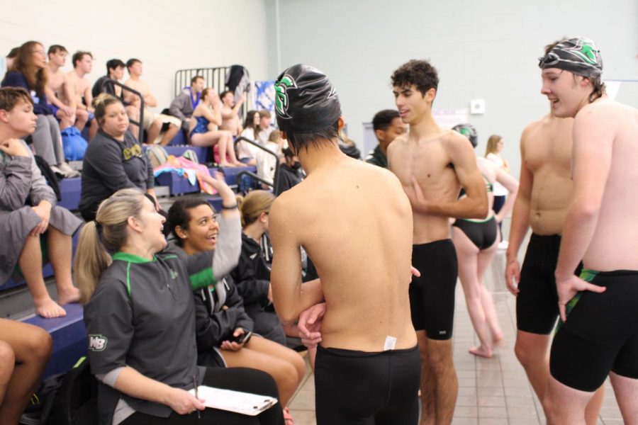 Swimmers gather around Coach Fletcher.