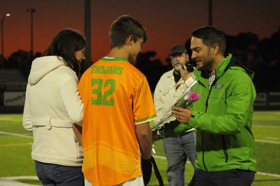 Senior Paul Gushman walked by his mom during senior night as he gets greeted by Mr. Paschal. 
