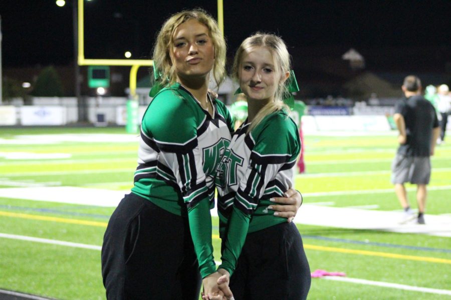 Sophomore McKenleigh Popejoy and Candyce Benge pose on the sidelines.