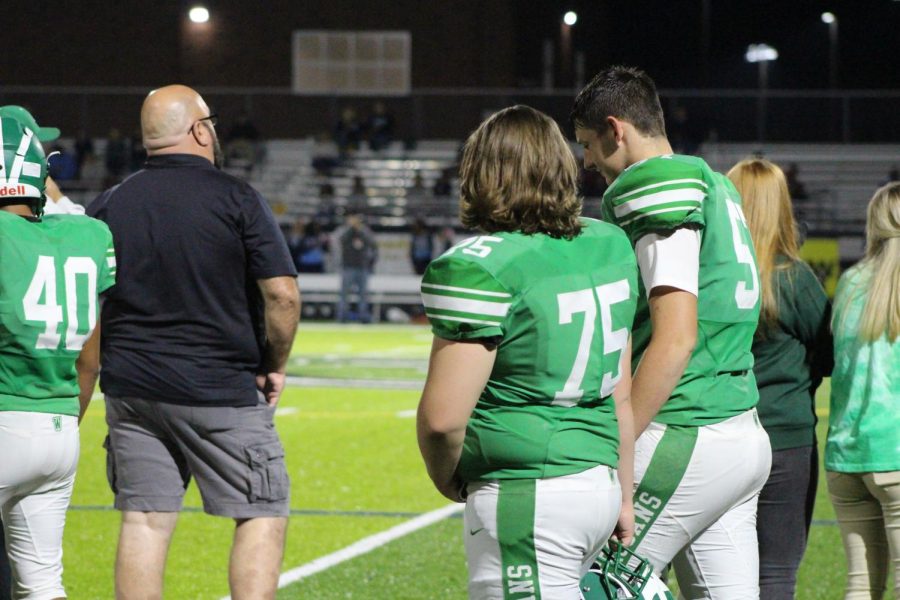 Brian Segars and Bailey Tripp talking on the sidelines.