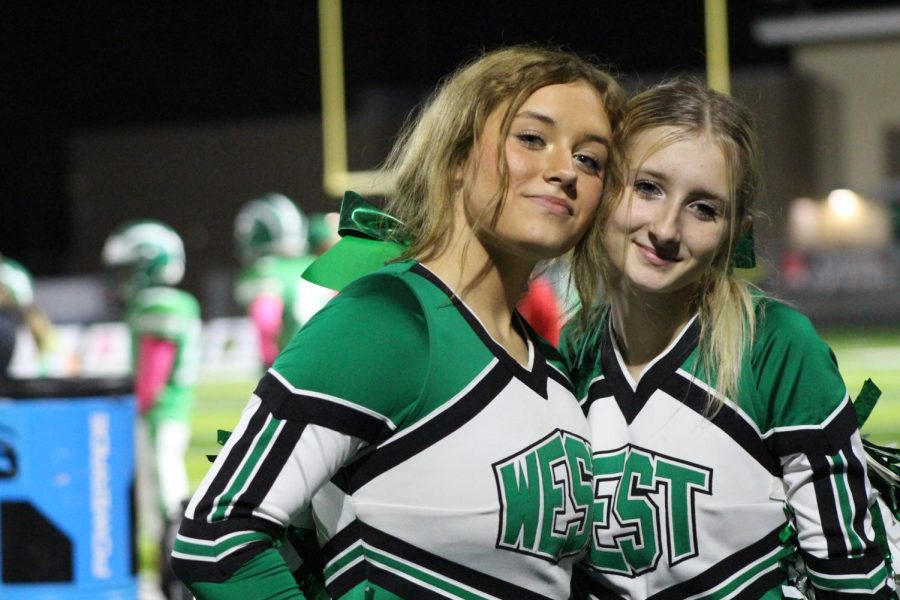 JV cheerleaders McKenleigh Popejoy and Candyce Benge pose for a picture on the sidelines.