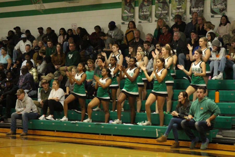 The cheerleading team and others cheering for the team. 