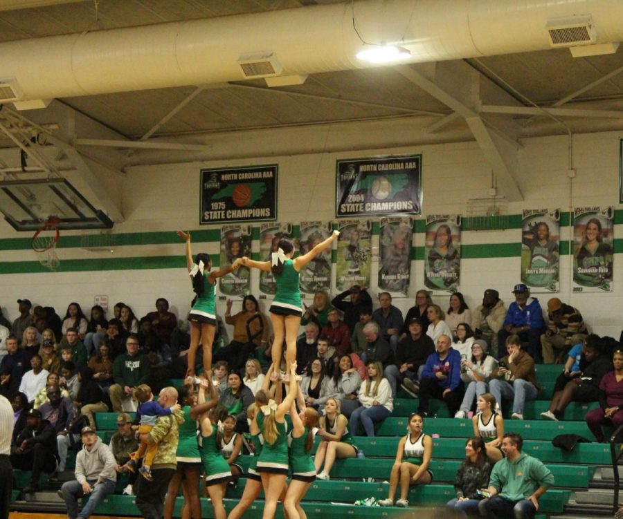 The cheerleaders in a stunt interacting with the crowd.