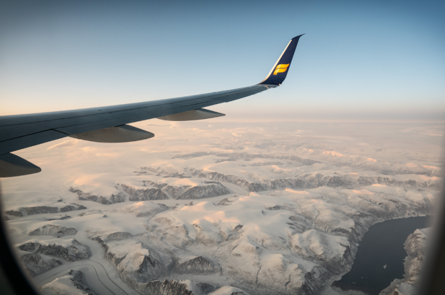 Wing of Airplane Flying Over a Mountain Range