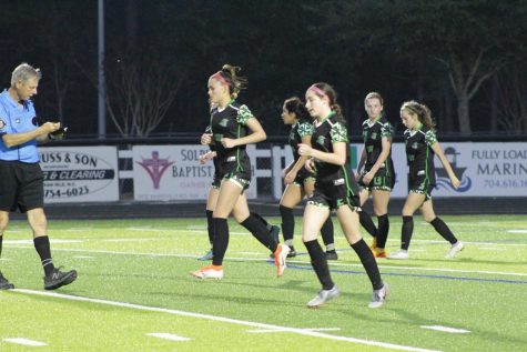 The Womens Varsity Soccer team running back after scoring a goal.