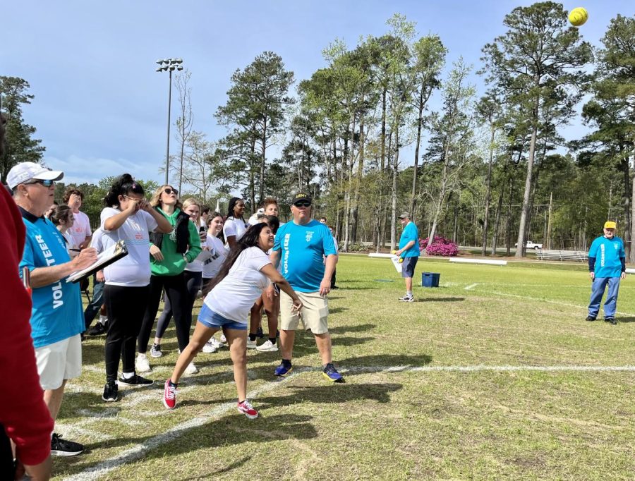 Stacey Garcia Hernandez competing in the softball throwing competition, while her peers watch and cheer her on. 