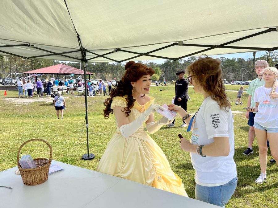 Mia Pittarelli receiving an autographed card from the Disney princess, Belle.
