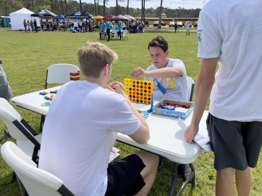 Senior Carson Pope playing Connect 4 with Dylon Whaley after finishing their events.