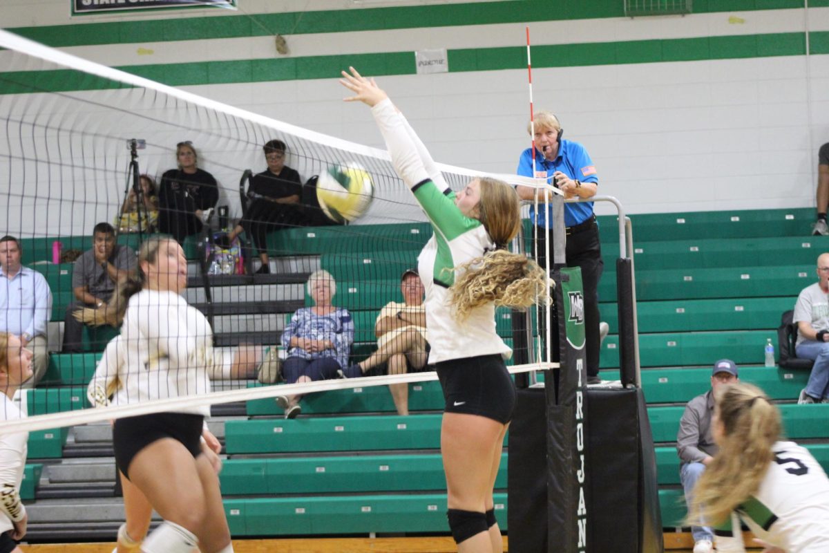 Sophomore Kelsey Lykins spikes the ball over the net. The opposing team lets the ball fall. 