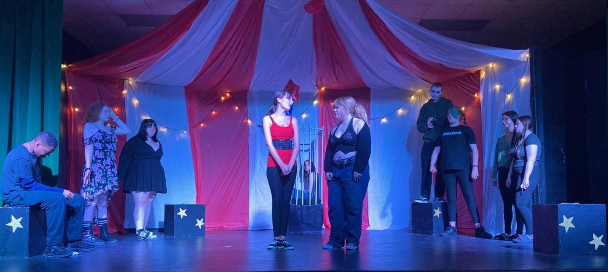 Alexis Mullins and Meadow Stocks stand center stage with faces looking towards one another. 