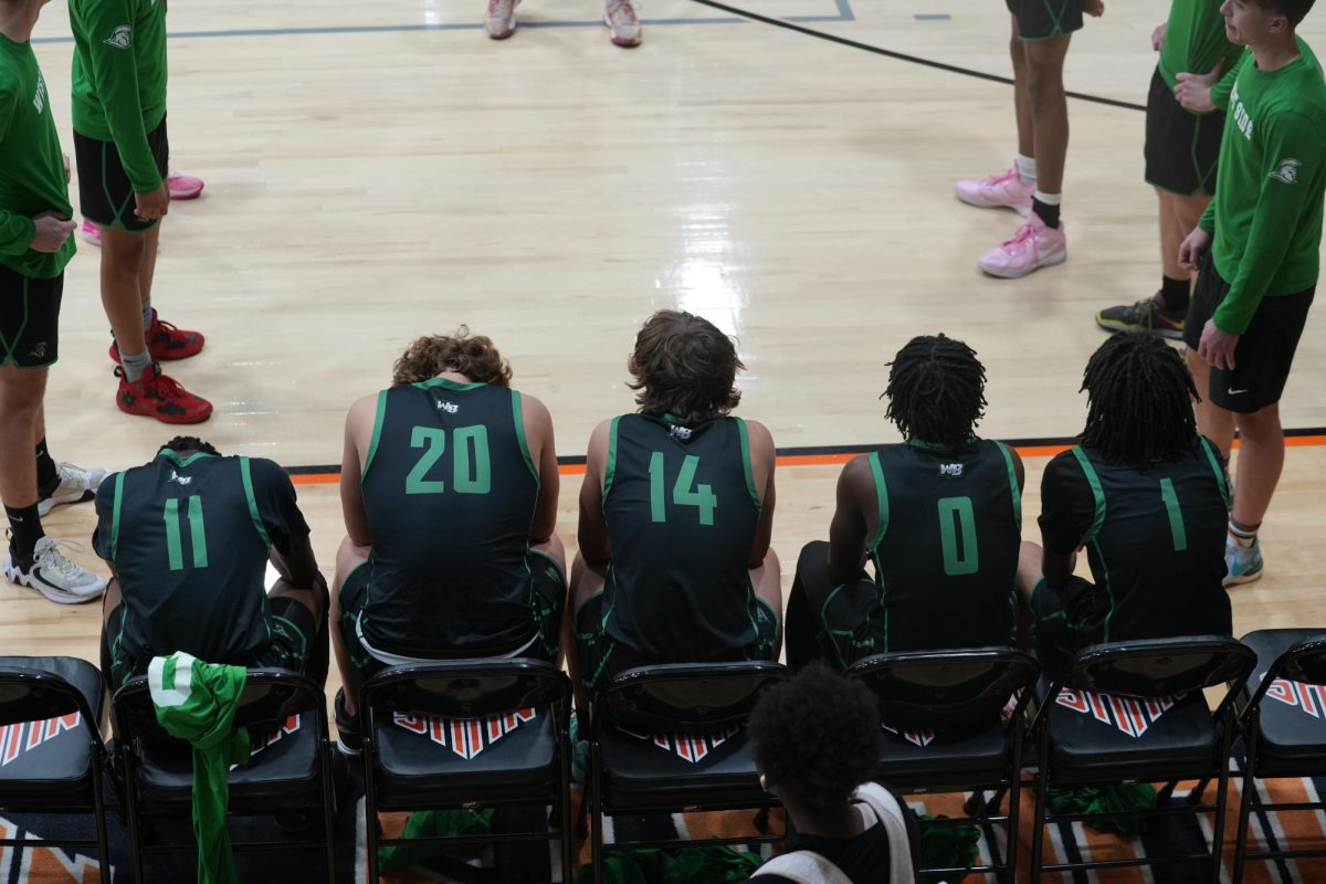 The starting five sitting on the bench ready to be called out before the game starts.