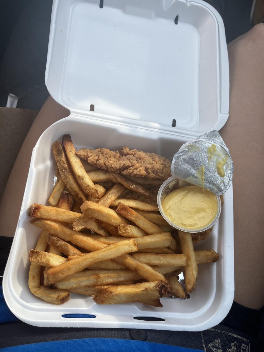 A Chicken tender tray from cookout with fries and honey mustard.