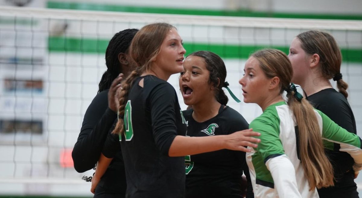 The Trojans coming together and cheering after they scored a point.