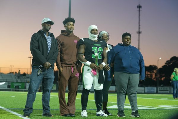 Football player, Javonta Daniels, walking with his mom, two brothers, and uncle.