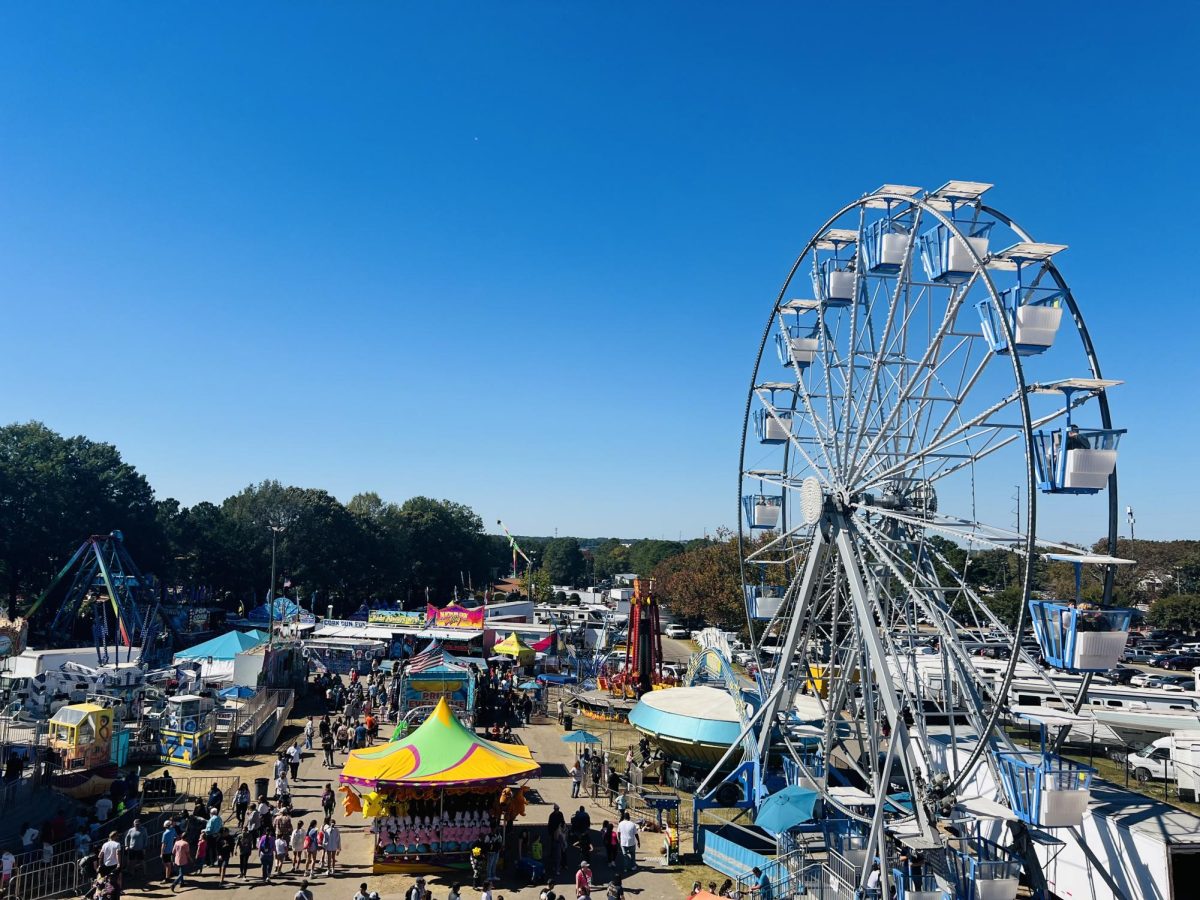 The ferris wheel at the grounds is an attractive background for all the booths and rides.