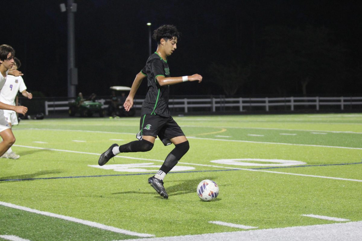 Melvin Bausita dribbling the ball to find an open teammate to pass to.