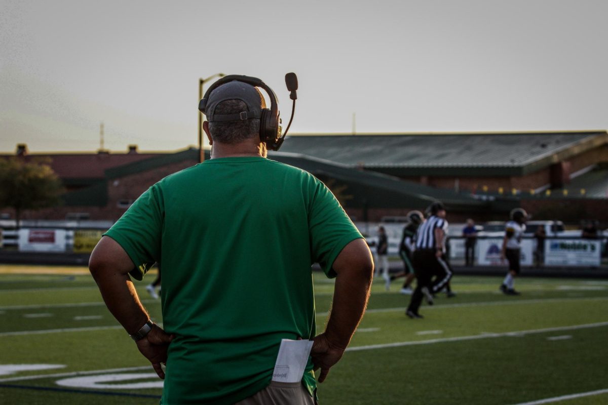 Coach Alan Bryant watches his team telling them what is next. 