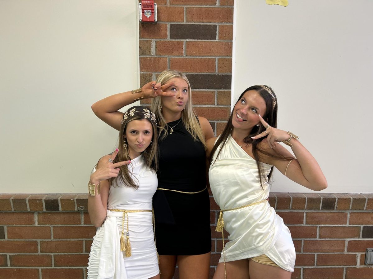 Seniors Joslyn Paolino, Macie Long and Ella Belamy strike a pose in their togas during lunch. 