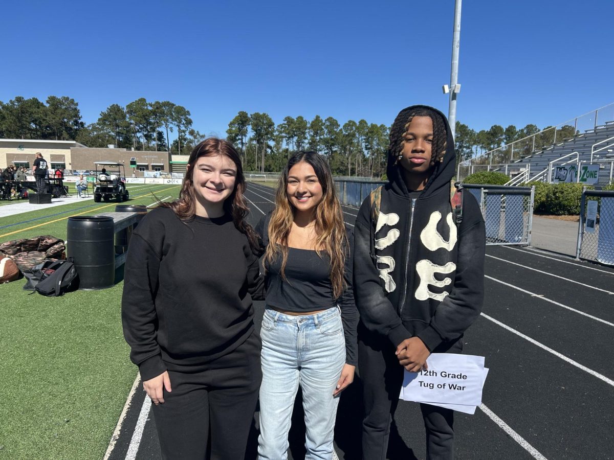 West Wind staff members Savannah Robinson, Kayley Arevalo and Jordan Thomas stand in their colors preparing for the Pep Rally. 