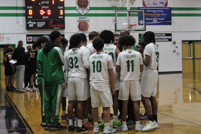 West Brunswick JV boys basketball team huddling talking about there next strategies .