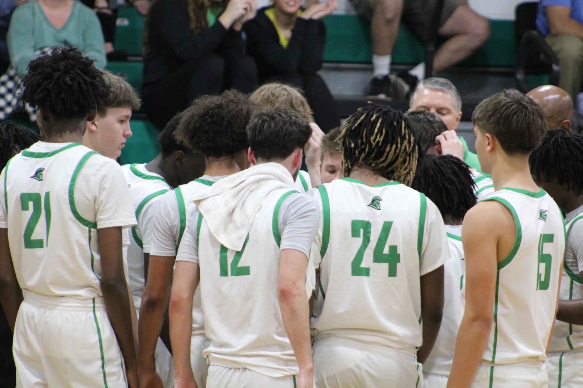 Entire varsity basketball team huddled up during a time out. 