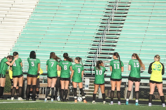 Varsity Women's Soccer team lined up and ready for the game to start.