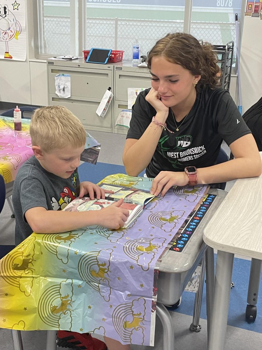 Maddie Bermudez helping her little read a book. 