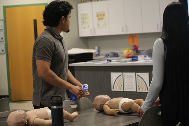 Josue Herrera watching video to learn the next step of CPR on a infant. 