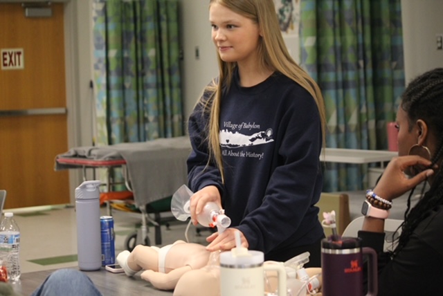 Erin Bohrer looking at teacher as she is trying to attempt CPR on infant 