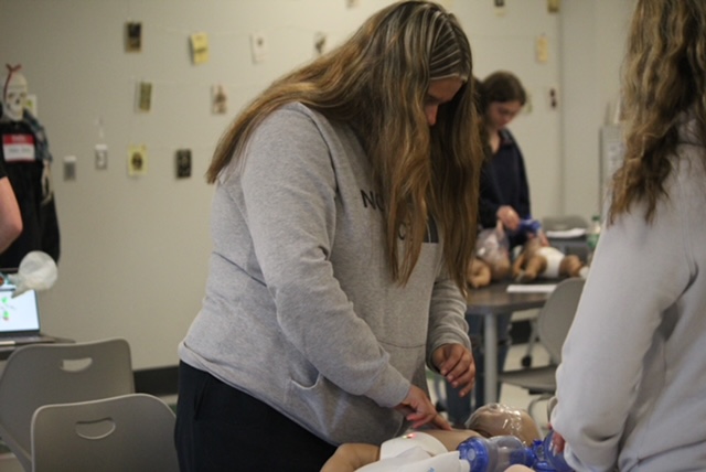 student performing chest compression's. 