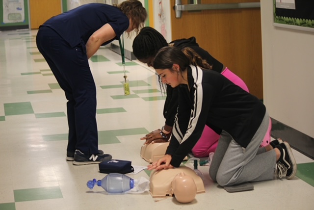 Mrs. Rohr helping two of her students as they are checking off for the course. 