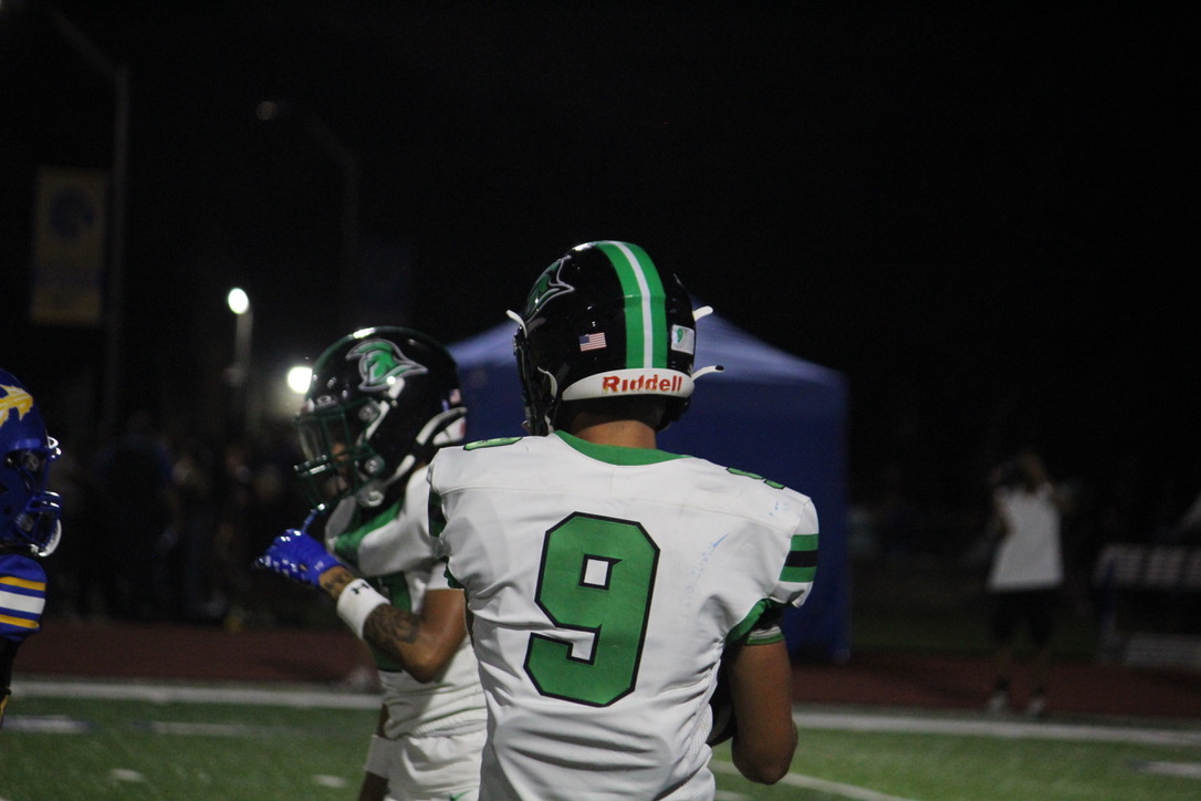 Trojan player approaching his teammate.