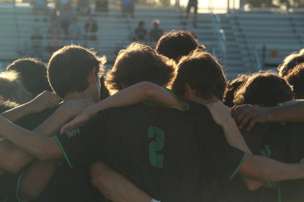 Mens varsity soccer team huddled up before the match starts.