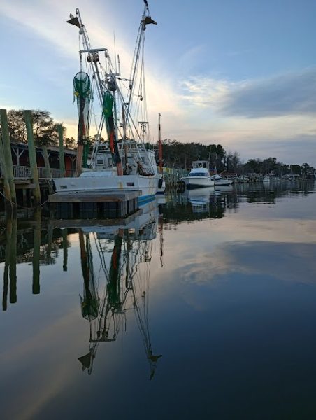 A shrimp boat sitting idly in the waters of Varnamtown.