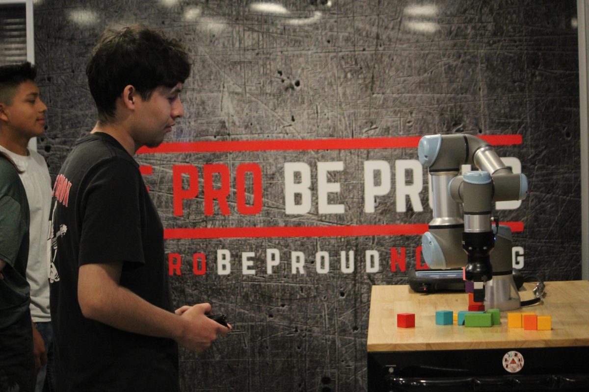 Student using the Remote controlled simulator to move blocks with machine. 